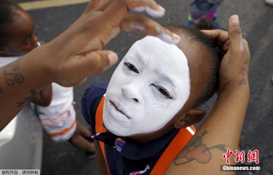  当地时间2015年8月8日，美国密苏里州弗格森镇，美国民众纪念非裔青年迈克·布朗被白人警察击毙一周年。示威现场，一些黑人将自己的脸涂成白色，以抗议种族歧视和白人警察的暴力执法。  